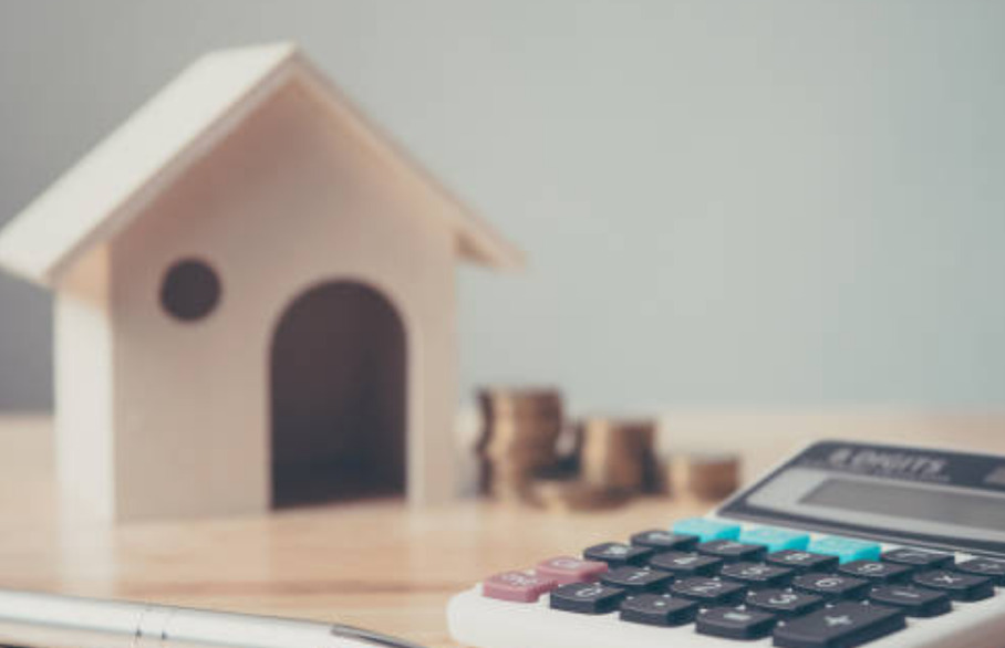 Calculator, pen and model house