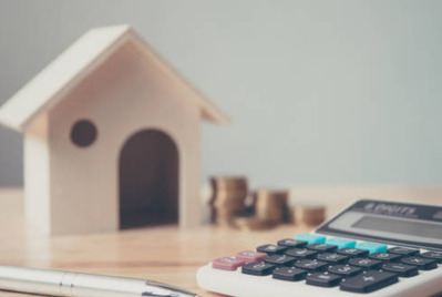 Calculator, pen and model house