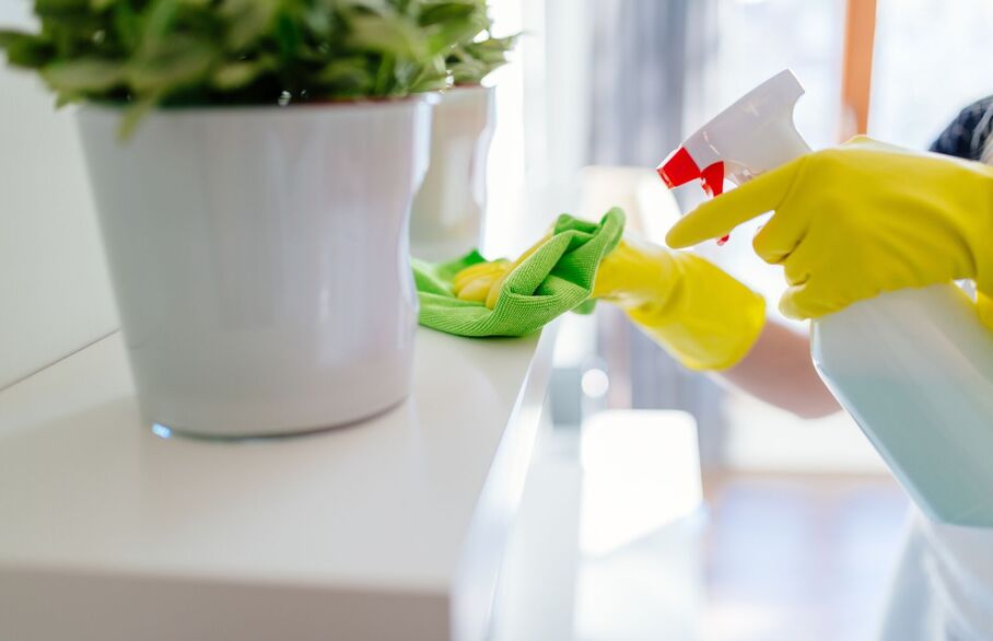 Close up of shelf being cleaned with cloth and spray