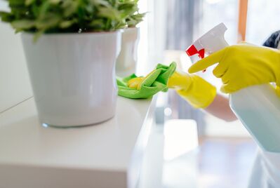 Close up of shelf being cleaned with cloth and spray