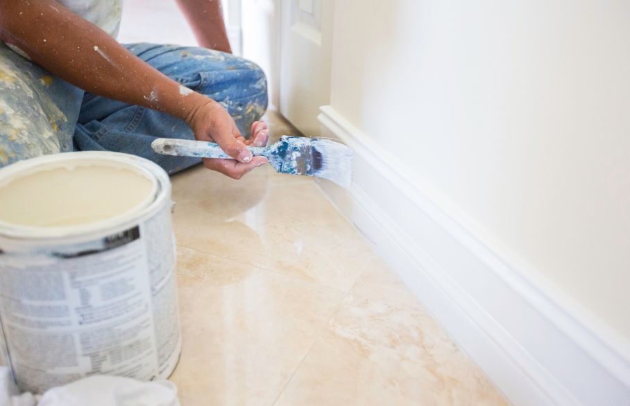 Close up of someone painting skirting