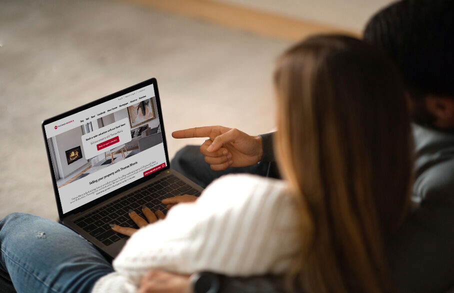 Two people looking at the Thomas Morris website on a laptop