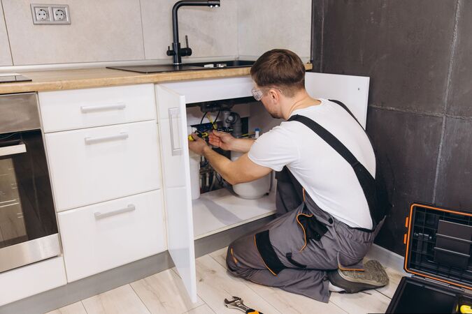 handy man fixing sink
