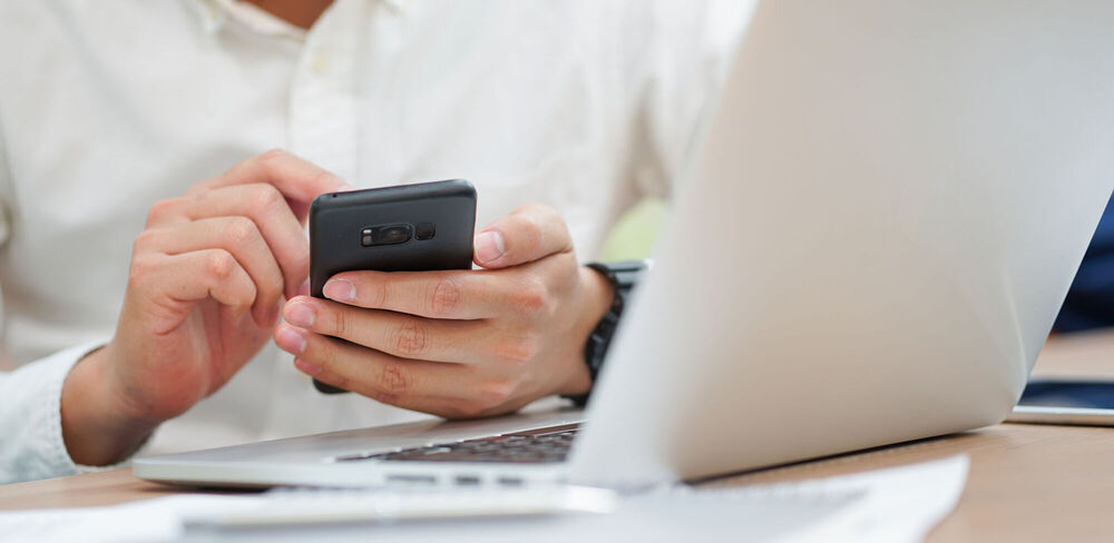 someone using a phone and laptop