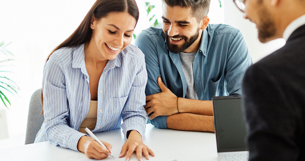 estate agent with couple signing a tenancy agreement