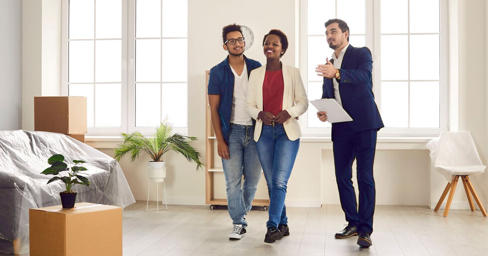 estate agent with couple looking round a property