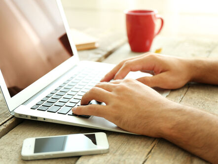 Man on a laptop with a red cup