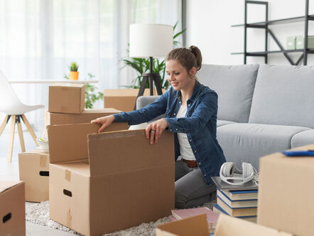 woman unpacking box in her front room