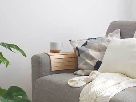 Comfy grey sofa with cushions and coffee cup