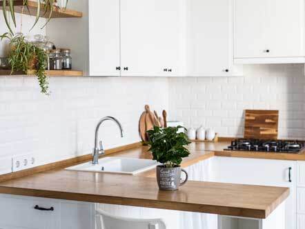 Small white kitchen with wooden work surfaces