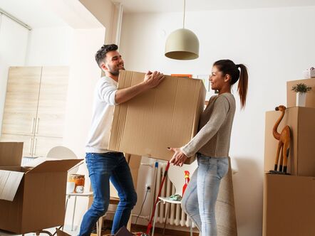 Two people carrying a cardboard box