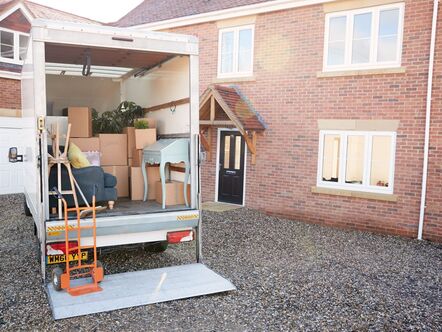 A moving van full of boxes in front of a house