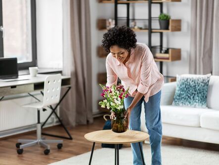 A woman arranging flowers on a table