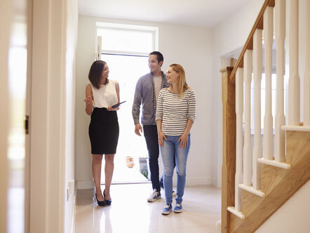 An estate agent showing two people round a house