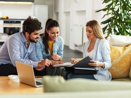 Three people having a meeting looking at papers